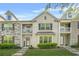 Beautiful townhome with stone and brick facade, upper balconies, and a well-maintained lawn at 7691 Cabrini Pl, Fairburn, GA 30213