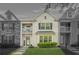 Striking townhome showcasing stone and brick facade, upper balconies, and a lush green lawn at 7691 Cabrini Pl, Fairburn, GA 30213