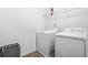 Functional laundry room with washer, dryer, and shelving for storage at 7691 Cabrini Pl, Fairburn, GA 30213