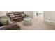 Spacious living room featuring a comfortable leather sofa and a stylish coffee table at 7691 Cabrini Pl, Fairburn, GA 30213