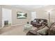 Cozy living room with a plush leather sofa, marble-topped table, and a mounted television at 7691 Cabrini Pl, Fairburn, GA 30213