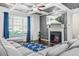Beautiful living room featuring a fireplace, large window, coffered ceiling, and grey paint at 7691 Cabrini Pl, Fairburn, GA 30213