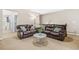 Inviting living area with plush leather sofas, a chic marble coffee table, and neutral tones at 7691 Cabrini Pl, Fairburn, GA 30213