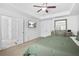 Comfortable main bedroom with a tray ceiling, ceiling fan, and ample closet space at 7691 Cabrini Pl, Fairburn, GA 30213