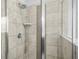 Close-up of a modern shower featuring tile walls and a glass enclosure at 7691 Cabrini Pl, Fairburn, GA 30213