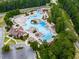 Aerial view of a community pool featuring multiple pools, slides, and seating areas surrounded by trees at 907 Fox Croft Pl, Canton, GA 30114