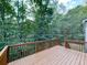 Wooden back deck and railing surrounded by lush, dense green trees at 907 Fox Croft Pl, Canton, GA 30114