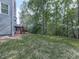 View of the backyard with a spacious lawn and wooden deck in a wooded area at 907 Fox Croft Pl, Canton, GA 30114