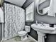 Cozy bathroom features a pedestal sink, toilet, and shower with a floral curtain at 907 Fox Croft Pl, Canton, GA 30114