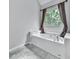 Bright bathroom showcasing a soaking tub beneath a window with nature views and brown curtains at 907 Fox Croft Pl, Canton, GA 30114