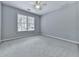 This spacious bedroom offers neutral carpet, a large window for light and a ceiling fan at 907 Fox Croft Pl, Canton, GA 30114