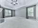Spacious bedroom with tray ceilings, gray walls, carpet, and large windows at 907 Fox Croft Pl, Canton, GA 30114