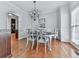 Elegant dining room with hardwood floors, a chandelier, wainscoting, and a large window with natural light at 907 Fox Croft Pl, Canton, GA 30114