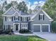 Charming two-story home with gray siding, black shutters, manicured landscaping, and an attached two-car garage at 907 Fox Croft Pl, Canton, GA 30114