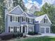 Two-story home with lush green grass, mature trees, and a long driveway leading to an attached two-car garage at 907 Fox Croft Pl, Canton, GA 30114