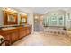 Bright bathroom boasts a walk-in shower, soaking tub, double vanity, and tile floors at 998 Ferncliff Ne Rd, Atlanta, GA 30324