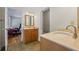Well-lit bathroom featuring double vanities, a tile floor, and an adjacent bedroom for convenience at 998 Ferncliff Ne Rd, Atlanta, GA 30324