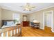 Bright bedroom featuring hardwood floors, a ceiling fan, and an adjacent home office space at 998 Ferncliff Ne Rd, Atlanta, GA 30324