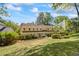 Large home exterior with a well-manicured lawn, patio seating, and mature landscaping at 998 Ferncliff Ne Rd, Atlanta, GA 30324
