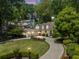 Stunning exterior view of a home with a lush green lawn and a winding driveway, and a three car garage at 998 Ferncliff Ne Rd, Atlanta, GA 30324