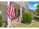 Close-up of charming front porch with brick steps, columns, and flagpole with US flag at 998 Ferncliff Ne Rd, Atlanta, GA 30324