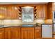 Kitchen featuring wood cabinets, undermount sink, stainless dishwasher, and stone backsplash at 998 Ferncliff Ne Rd, Atlanta, GA 30324