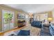 Living room featuring hardwood floors, plantation shutters, and a blue leather sofa at 998 Ferncliff Ne Rd, Atlanta, GA 30324