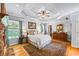 Relax in this charming main bedroom with a stone fireplace, tray ceiling, wooden floors, and bright windows at 998 Ferncliff Ne Rd, Atlanta, GA 30324