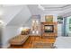 This primary bedroom features a stone fireplace, hardwood floors, a comfortable chaise lounge, and a bright window at 998 Ferncliff Ne Rd, Atlanta, GA 30324