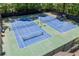 Aerial view of well-maintained tennis courts surrounded by lush greenery and a secure fence at 998 Ferncliff Ne Rd, Atlanta, GA 30324