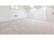 Finished basement room with neutral carpeting, white walls and ceilings, and natural light from a window at 224 Kings Hwy, Decatur, GA 30030