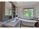 Relaxing bathroom with a freestanding tub, gray vanity with a sink, and a window at 2675 Dacula Ridge Dr, Dacula, GA 30019