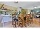Open dining room featuring a large wooden table, hardwood floors, and a breakfast bar with bar stools at 2675 Dacula Ridge Dr, Dacula, GA 30019