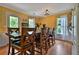 Sunny dining room featuring a large wooden table, hardwood floors, and a view to the outdoors at 2675 Dacula Ridge Dr, Dacula, GA 30019
