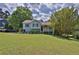 Quaint home showcasing a lush green lawn, mature trees, and a charming front porch with patriotic decor at 2675 Dacula Ridge Dr, Dacula, GA 30019