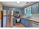 Traditional kitchen features stainless steel appliances, hardwood floors, and blue cabinetry at 2675 Dacula Ridge Dr, Dacula, GA 30019