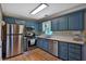 Traditional kitchen features stainless steel appliances, hardwood floors, and blue cabinetry at 2675 Dacula Ridge Dr, Dacula, GA 30019