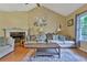 Inviting living room featuring a vaulted ceiling, hardwood floors, comfortable seating, and a decorative fireplace at 2675 Dacula Ridge Dr, Dacula, GA 30019
