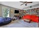 Living room featuring a ceiling fan, red sofa, television and exterior door at 2675 Dacula Ridge Dr, Dacula, GA 30019