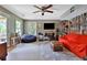 Living room featuring a ceiling fan, red sofa, television and exterior door at 2675 Dacula Ridge Dr, Dacula, GA 30019