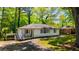 Inviting single-story home with a white exterior, a covered carport, and a well-maintained front yard with mature trees at 754 Pinehill Se Dr, Smyrna, GA 30080