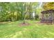 Backyard featuring mature trees and a gazebo nestled among lush greenery and lawn at 1763 Hearthstone Cir, Lawrenceville, GA 30043