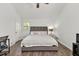 Bright bedroom featuring a queen bed, ceiling fan, and a conveniently placed desk and chair set at 1763 Hearthstone Cir, Lawrenceville, GA 30043