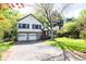 Charming two-story home featuring a stone facade, red door, two-car garage and a well-manicured lawn and mature trees at 1763 Hearthstone Cir, Lawrenceville, GA 30043