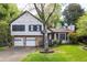 Charming two-story home featuring a stone facade, red door, two-car garage and a well-manicured lawn and mature trees at 1763 Hearthstone Cir, Lawrenceville, GA 30043