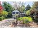 Charming two-story home featuring a stone facade, red door, two-car garage and a well-manicured lawn and mature trees at 1763 Hearthstone Cir, Lawrenceville, GA 30043