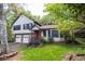Charming two-story home featuring a stone facade, red door, two-car garage and a well-manicured lawn and mature trees at 1763 Hearthstone Cir, Lawrenceville, GA 30043