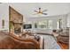 Inviting living room with stone fireplace, ceiling fan, hardwood floors, and large windows for natural light at 1763 Hearthstone Cir, Lawrenceville, GA 30043