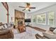 Inviting living room with stone fireplace, ceiling fan, hardwood floors, and large windows for natural light at 1763 Hearthstone Cir, Lawrenceville, GA 30043