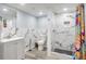 Modern bathroom featuring a walk-in shower with marble-look tiles, a gray vanity, and colorful shower curtain at 2162 Doris Dr, Decatur, GA 30034